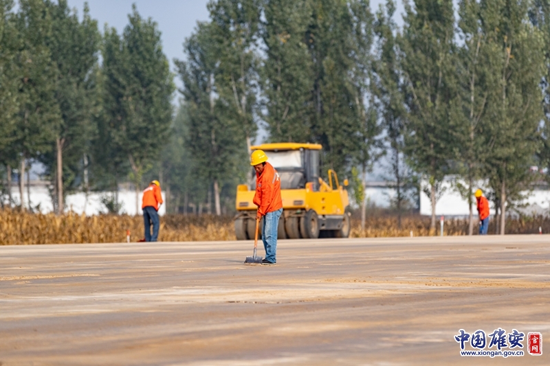 辛勤的施工人员正在整理马路上的石子。中国雄安官网高盟 摄