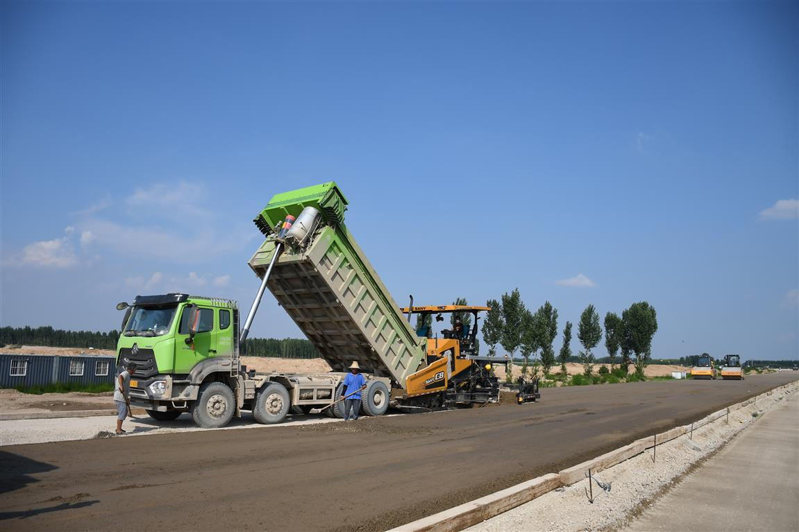 G337国道第二标段施工人员正在对该路段部分路面进行第三层水泥稳定碎石摊铺工作，该标段自京港澳高速至107京广铁路西侧，全长约5.2公里。薛宁摄